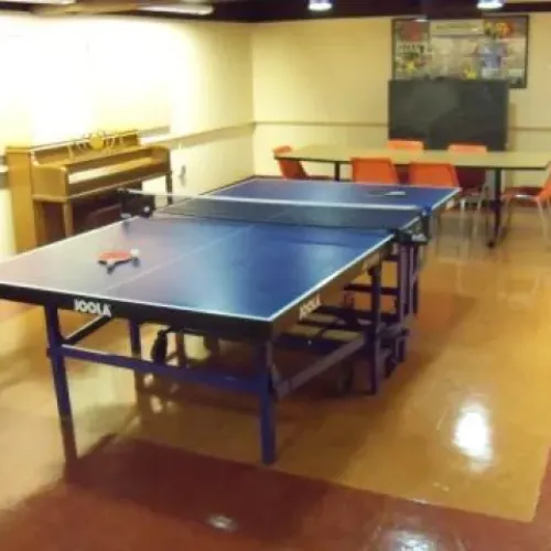 A games room with a ping-pong table and a small electric organ
