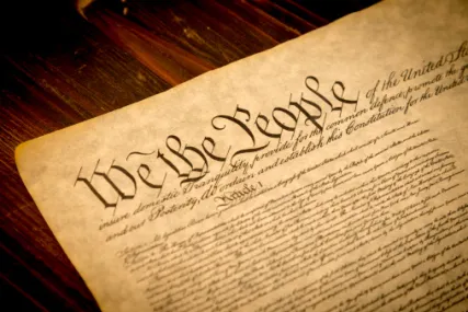An image of the United States Constitution featuring the large "We the People" preamble