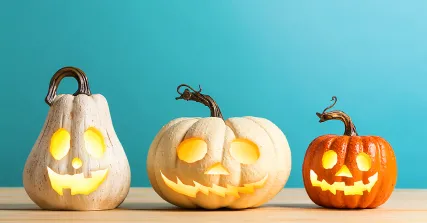 Three jack-o'-lanterns on a table.