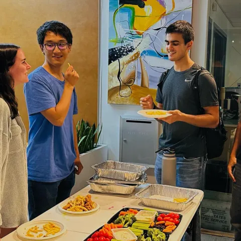 Radian residents meet up in a lobby while snacking on a vegetable tray