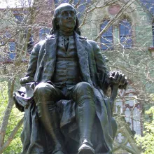A statue of Benjamin Franklin in front of College Hall at the University of Pennsylvania