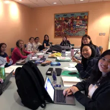 Women around a conference table with laptop computers