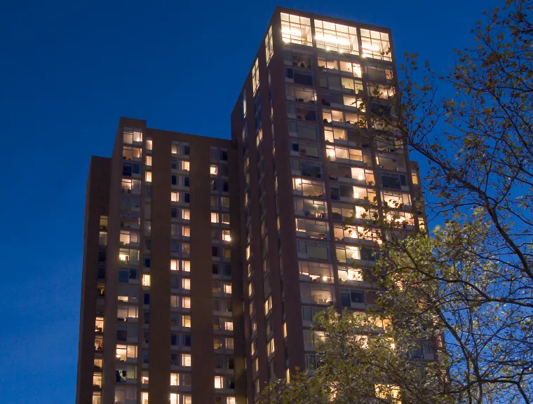 The upper floors of Harrison in late evening, with the lights shining out the windows onto a very deep blue sky