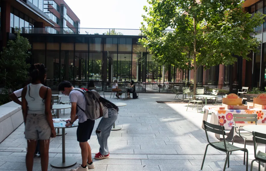 Gutmann Courtyard set up for a House event, with students gathered around a table