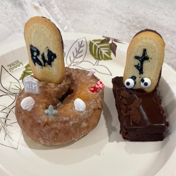 Left, a doughnut with a cookie tombstone reading RIP, right, a brownie with a cookie tombstone