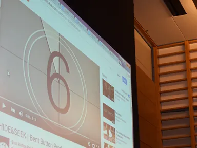 A film countdown plays on a large auditorium screen at a College House Film Festival screening.