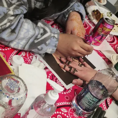 Henna is applied to the hand of a student