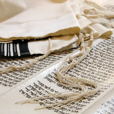 A tallit lying atop a Hebrew document