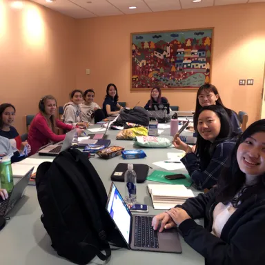 Women around a conference table with laptop computers